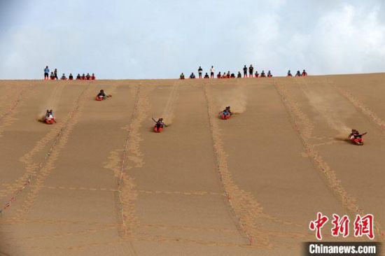 6月13日，敦煌鳴沙山月牙泉景區(qū)舉辦滑沙比賽。　張曉亮 攝