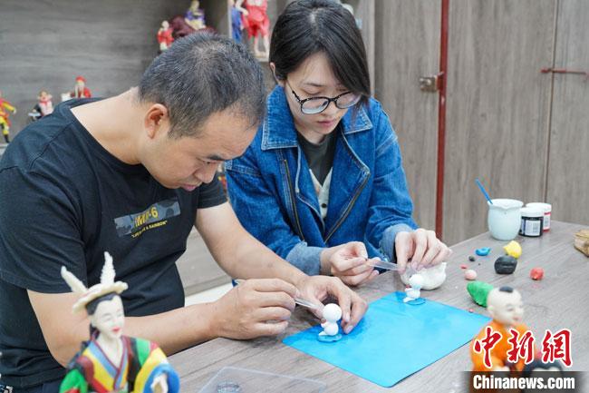<a target='_blank'  data-cke-saved- >中新社</a>記者(右)現(xiàn)場體驗面塑制作過程?！￡悹帍?攝