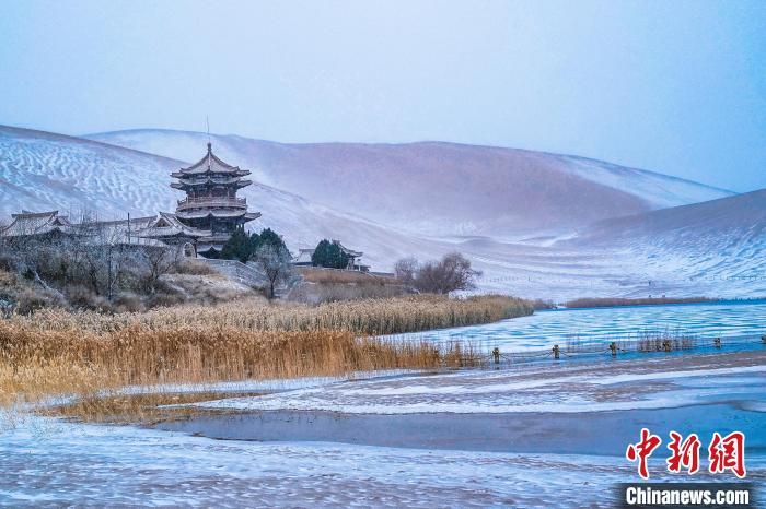 2021年11月28日，雪落鳴沙山月牙泉景區(qū)。　王斌銀 攝
