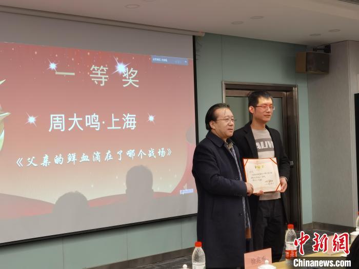 圖為作家、西北師范大學(xué)新聞與傳媒學(xué)院院長徐兆壽頒發(fā)一等獎證書，代領(lǐng)獎?wù)呱吓_領(lǐng)獎?！钅?攝