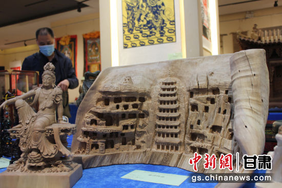 連日來，甘肅省工藝美術(shù)行業(yè)評審認定工作會議在蘭州舉行。圖為以敦煌莫高窟為題材的木雕作品《守護》。徐雪 攝