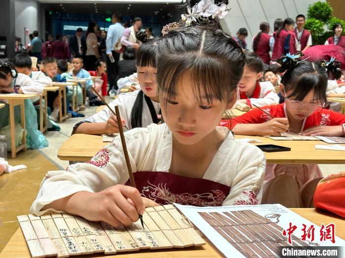 圖為小朋友在甘肅簡(jiǎn)牘博物館練習(xí)書(shū)法?！≈行律缬浾?戴文昌 攝
