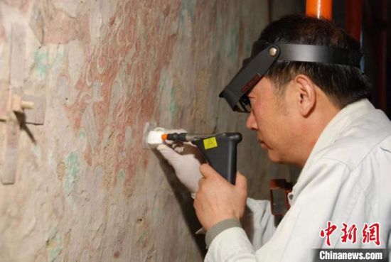 敦煌研究院研究員樊再軒進行壁畫修復。(資料圖)張云文 攝