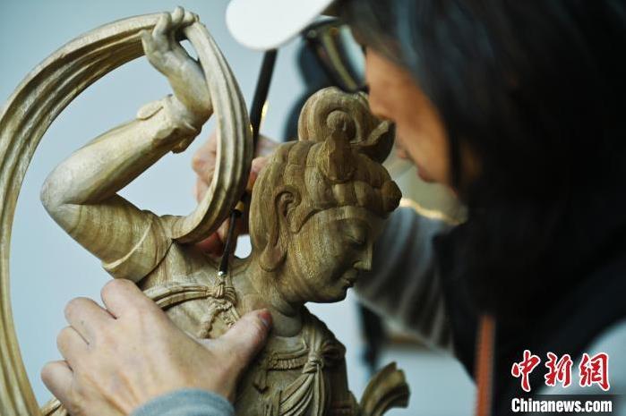 圖為季茂杰進(jìn)行敦煌元素的木雕創(chuàng)作。李亞龍 攝</p>
<p>