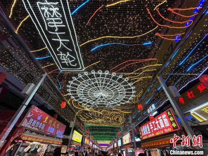 圖為明清街夜市燈光點(diǎn)亮具有武威文化元素的“摩天輪”彩燈。　戴文昌 攝</p><p>