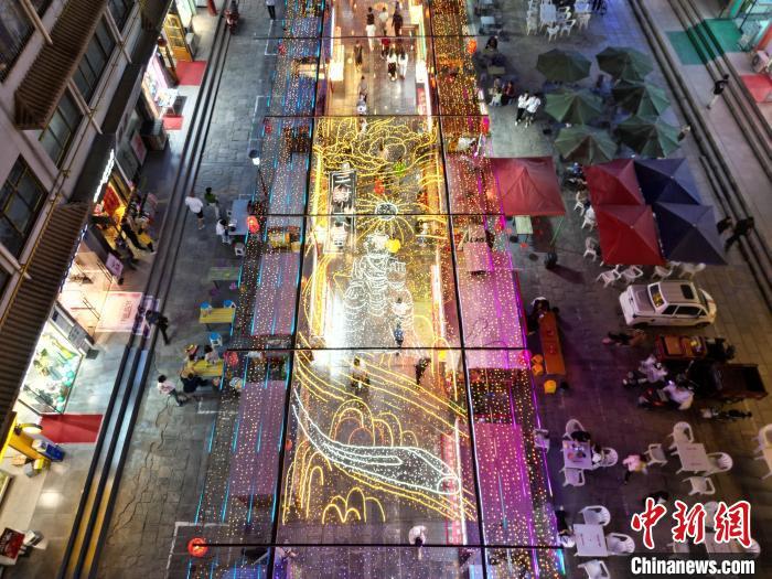 圖為明清街夜市燈光點(diǎn)亮具有武威文化元素的“天梯山石窟”彩燈。(無(wú)人機(jī)照片) 　戴文昌 攝</p><p>