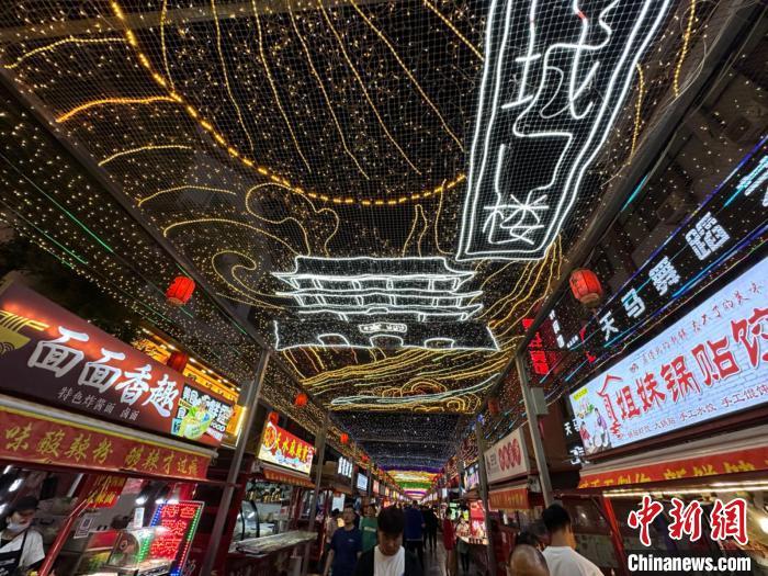 圖為明清街夜市燈光點(diǎn)亮具有武威文化元素的“涼州古城門”彩燈?！〈魑牟?攝</p><p>