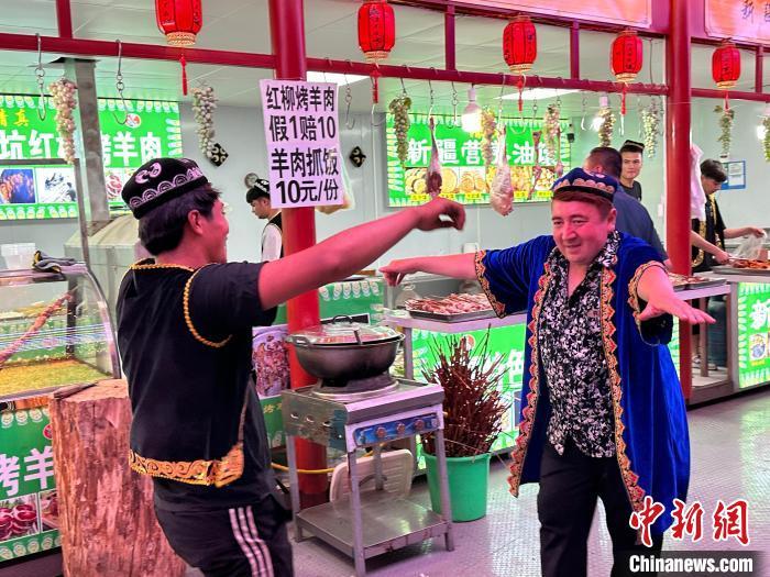 圖為餐飲經(jīng)營(yíng)者在“西涼不夜城”跳起舞蹈引客?！〈魑牟?攝</p><p>