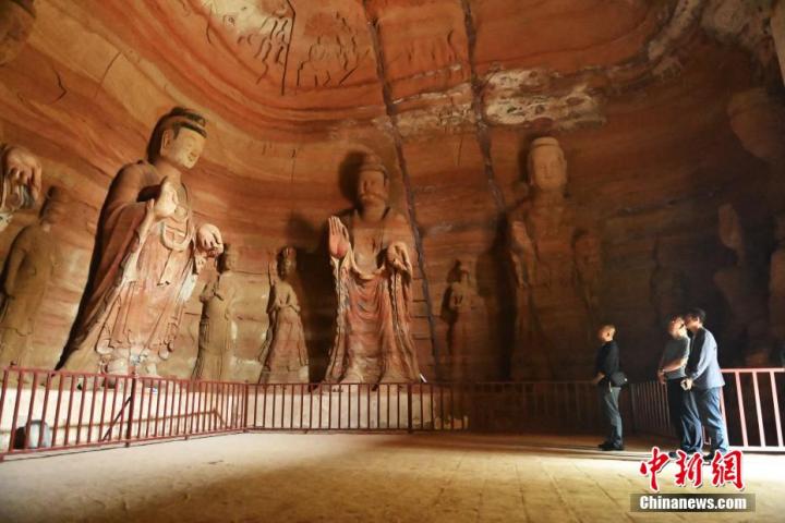 7月15日，游人參觀甘肅省平?jīng)鍪袥艽h百里石窟長(zhǎng)廊中的南石窟寺1號(hào)窟。百里石窟長(zhǎng)廊位于涇川縣境內(nèi)，由512個(gè)石窟、5眼窟中石井組成，現(xiàn)存王母宮石窟、鳳凰山石窟、南石窟寺、丈八寺石窟、羅漢洞石窟、太山寺石窟等規(guī)模較大的石窟群，還有數(shù)量眾多的小石窟群。南石窟寺開(kāi)鑿于北魏永平三年，其中1號(hào)窟屬于大型七佛窟，七佛高達(dá)6米。中新社記者 李亞龍 攝