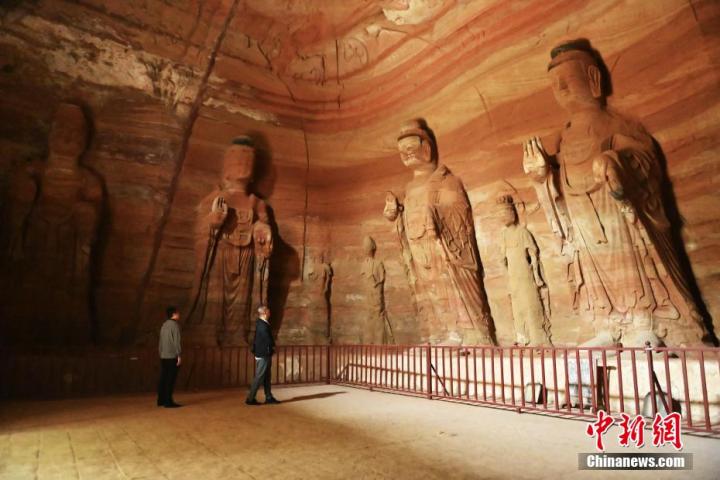 7月15日，游人參觀甘肅省平?jīng)鍪袥艽h百里石窟長(zhǎng)廊中的南石窟寺1號(hào)窟。百里石窟長(zhǎng)廊位于涇川縣境內(nèi)，由512個(gè)石窟、5眼窟中石井組成，現(xiàn)存王母宮石窟、鳳凰山石窟、南石窟寺、丈八寺石窟、羅漢洞石窟、太山寺石窟等規(guī)模較大的石窟群，還有數(shù)量眾多的小石窟群。南石窟寺開(kāi)鑿于北魏永平三年，其中1號(hào)窟屬于大型七佛窟，七佛高達(dá)6米。中新社記者 李亞龍 攝